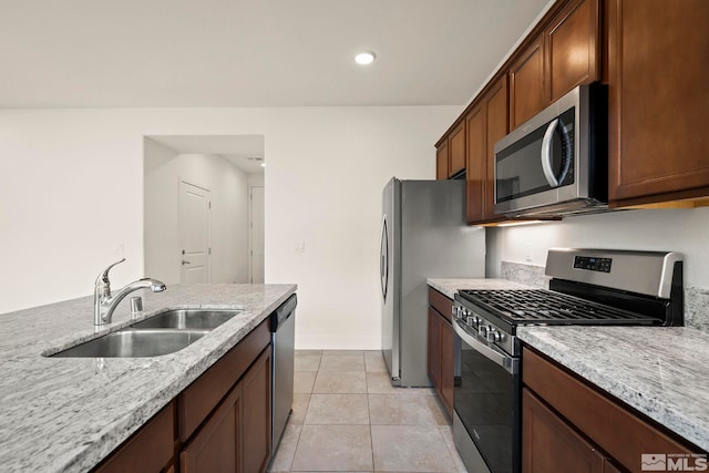 kitchen featuring light stone counters, sink, light tile patterned floors, and appliances with stainless steel finishes