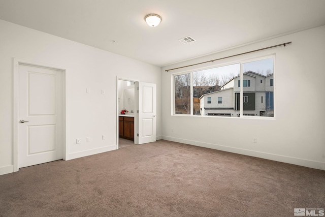 unfurnished bedroom featuring carpet floors and connected bathroom