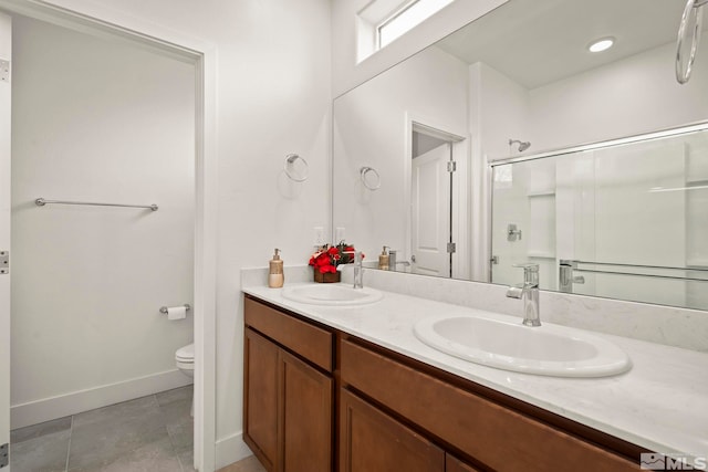 bathroom with vanity, toilet, tile patterned flooring, and a shower with door