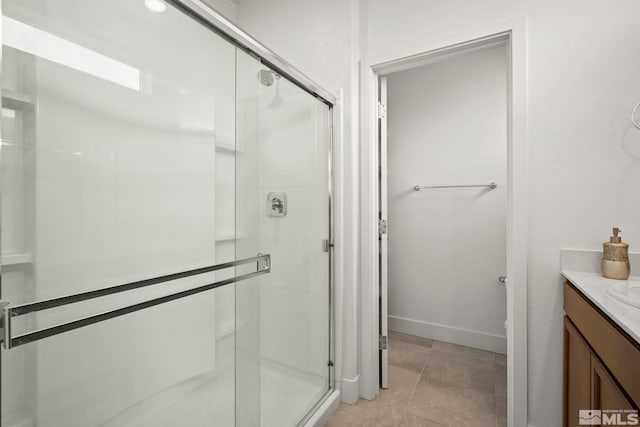 bathroom featuring vanity, tile patterned flooring, and a shower with door