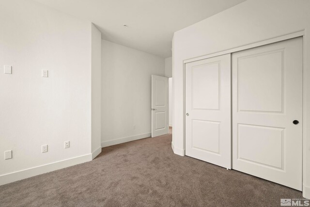 unfurnished bedroom featuring carpet floors and a closet