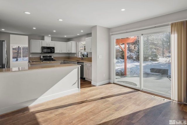 kitchen with white cabinetry, sink, light hardwood / wood-style flooring, and stainless steel appliances