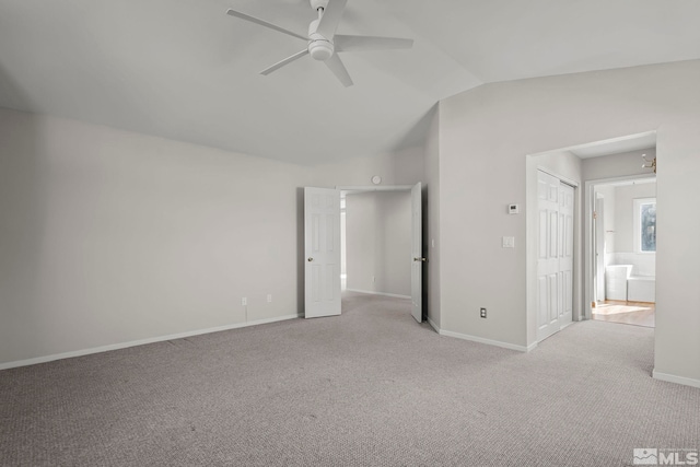 unfurnished bedroom with light carpet, vaulted ceiling, a closet, and ceiling fan