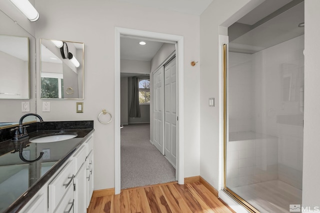 bathroom featuring vanity, hardwood / wood-style flooring, and a shower with shower door