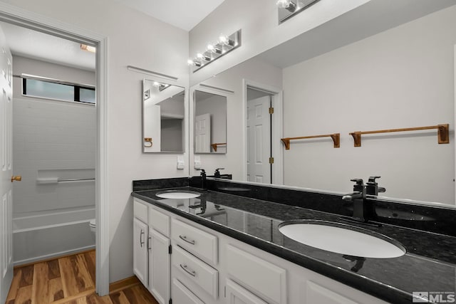 bathroom with vanity, hardwood / wood-style floors, and  shower combination