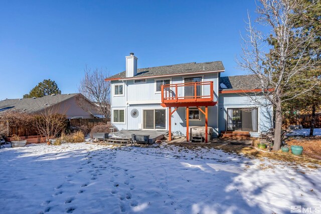 snow covered rear of property featuring a wooden deck