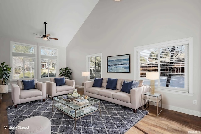 living room featuring dark wood-type flooring, ceiling fan, and high vaulted ceiling