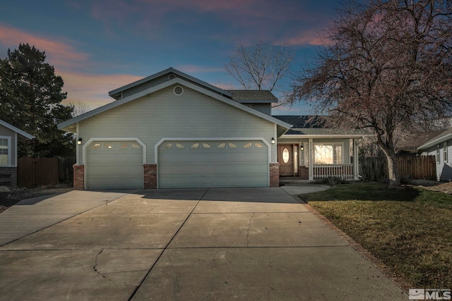 view of front of property with a porch, a garage, and a lawn