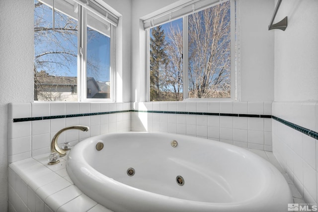 bathroom featuring a relaxing tiled tub and plenty of natural light