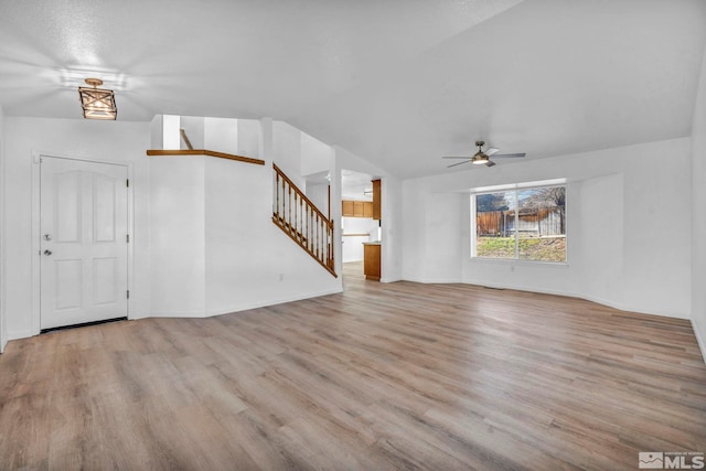 unfurnished living room with ceiling fan, lofted ceiling, and light hardwood / wood-style floors