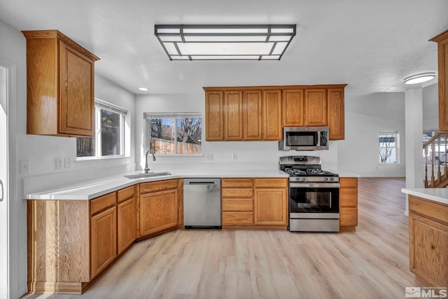 kitchen with sink, stainless steel appliances, and light wood-type flooring