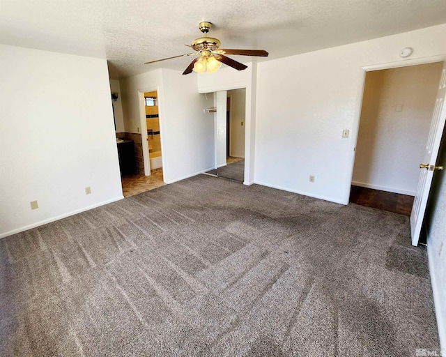 carpeted spare room with ceiling fan and a textured ceiling