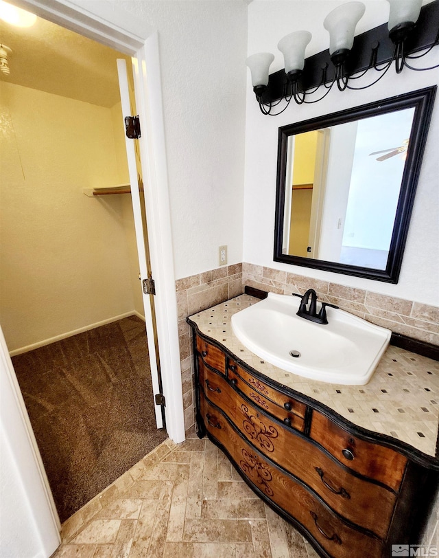 bathroom with vanity and tile walls