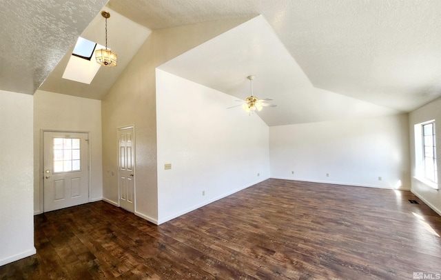 entryway with dark wood-type flooring, a skylight, high vaulted ceiling, a textured ceiling, and ceiling fan