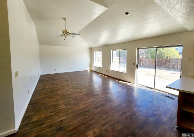unfurnished living room featuring dark wood-type flooring, ceiling fan, lofted ceiling, and a textured ceiling