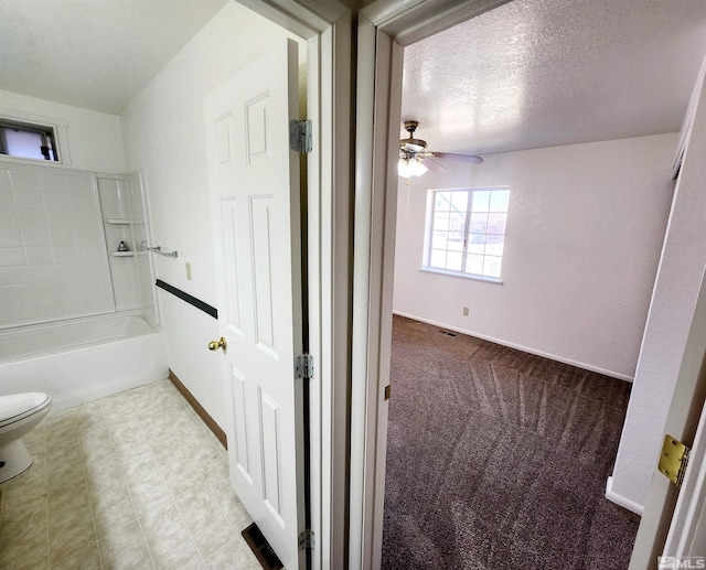 bathroom featuring ceiling fan, shower / bathing tub combination, a textured ceiling, and toilet