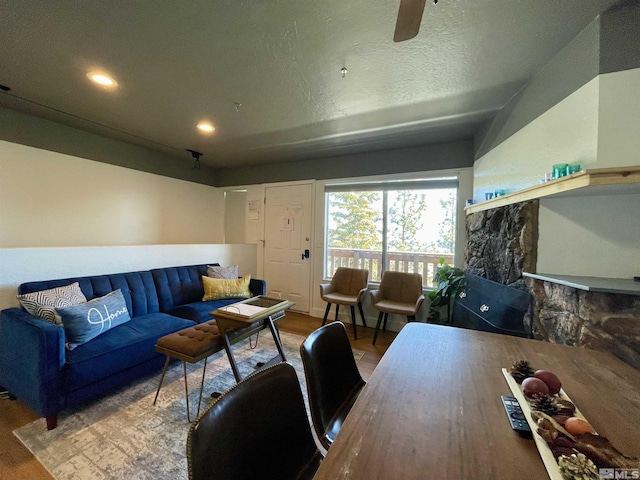 living room with ceiling fan, hardwood / wood-style floors, and a textured ceiling