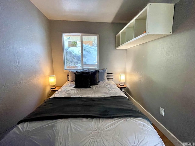 bedroom with a textured wall and baseboards