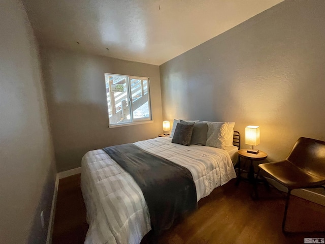 bedroom with dark wood-style floors