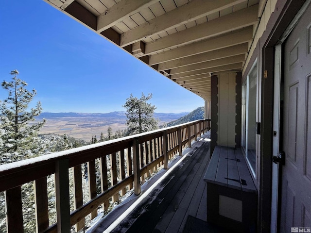 snow covered back of property with a mountain view