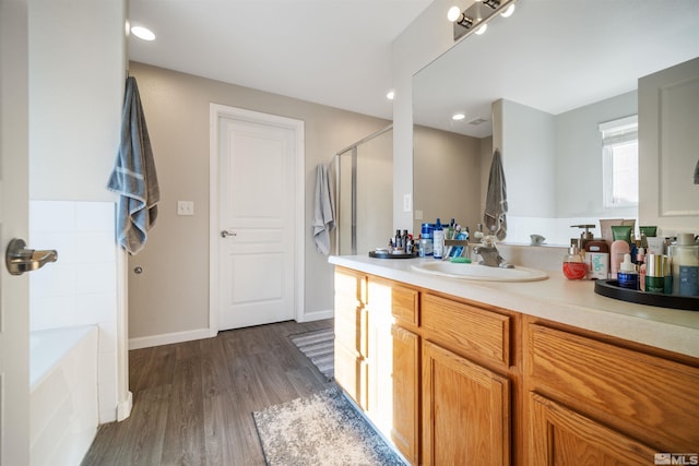 bathroom featuring vanity, hardwood / wood-style flooring, and separate shower and tub