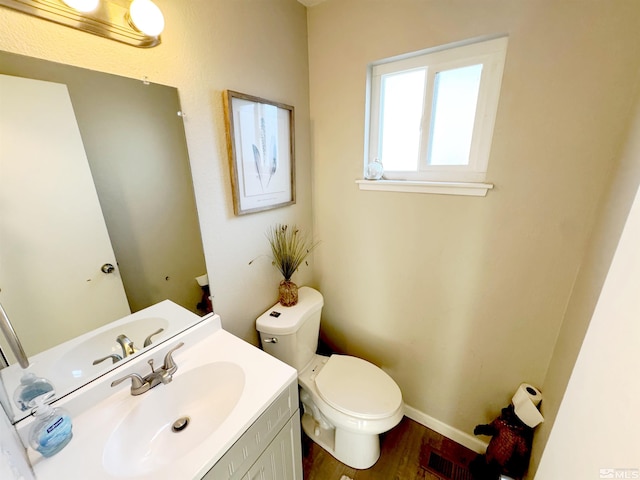 bathroom with vanity, toilet, and wood-type flooring