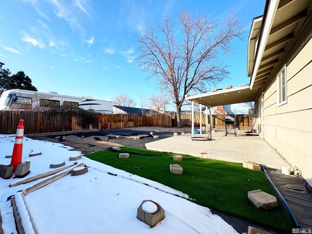 snowy yard featuring a patio area