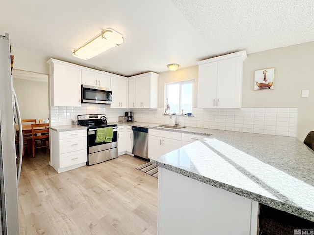 kitchen with appliances with stainless steel finishes, sink, and white cabinets