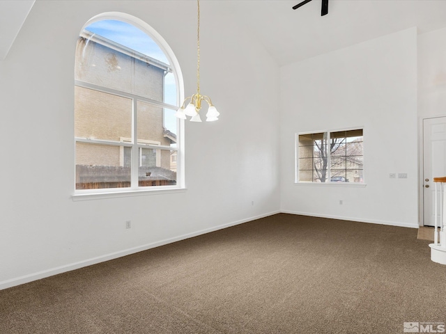 interior space featuring ceiling fan with notable chandelier, carpet floors, and high vaulted ceiling