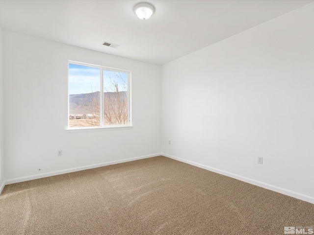 unfurnished room with a mountain view and carpet