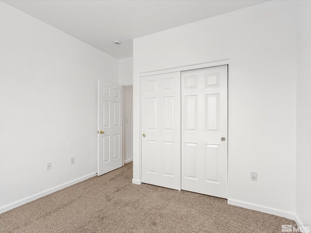 unfurnished bedroom with a closet and carpet