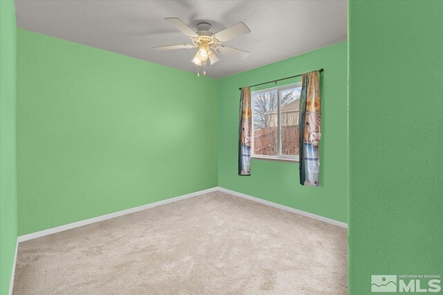 carpeted empty room featuring ceiling fan