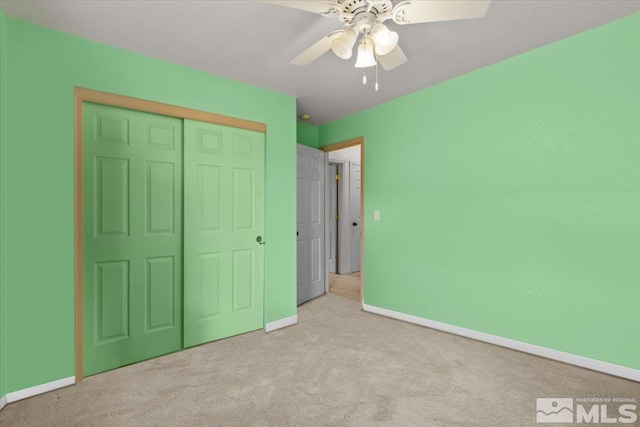 unfurnished bedroom with light carpet, a closet, and ceiling fan