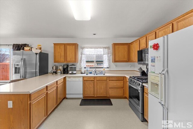 kitchen featuring appliances with stainless steel finishes, kitchen peninsula, and sink