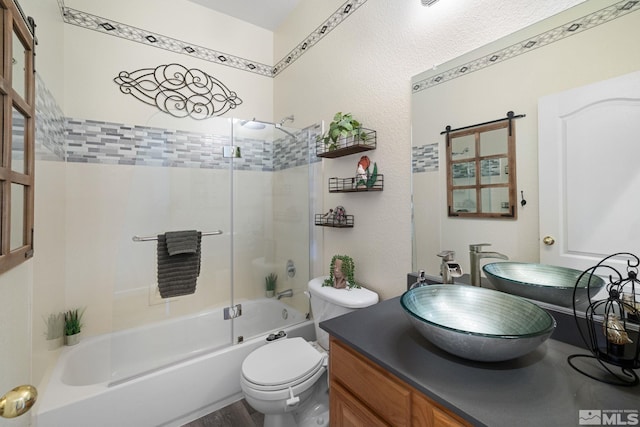 full bathroom featuring vanity, toilet, and combined bath / shower with glass door