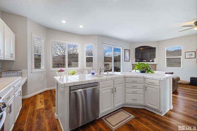 kitchen with white cabinetry, sink, tile countertops, and stainless steel dishwasher