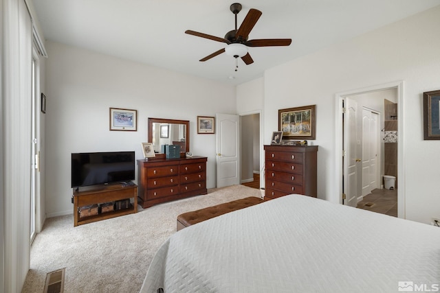 bedroom featuring light carpet, connected bathroom, and ceiling fan