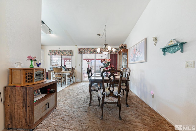 carpeted dining room with a chandelier