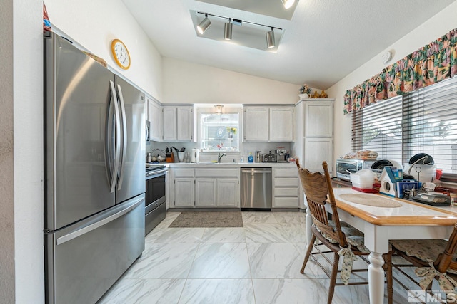 kitchen featuring gray cabinets, lofted ceiling, sink, stainless steel appliances, and a textured ceiling