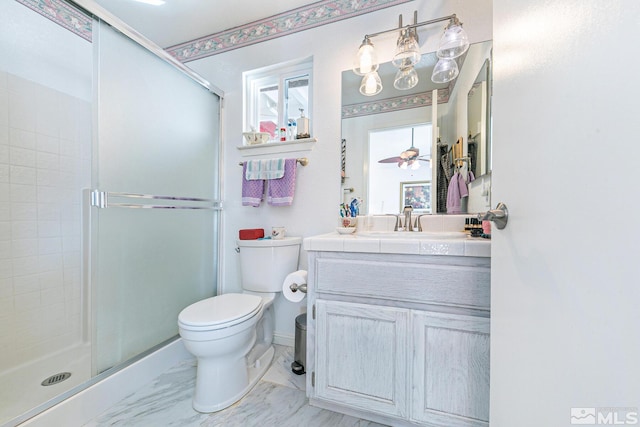 bathroom with walk in shower, ceiling fan, vanity, and toilet