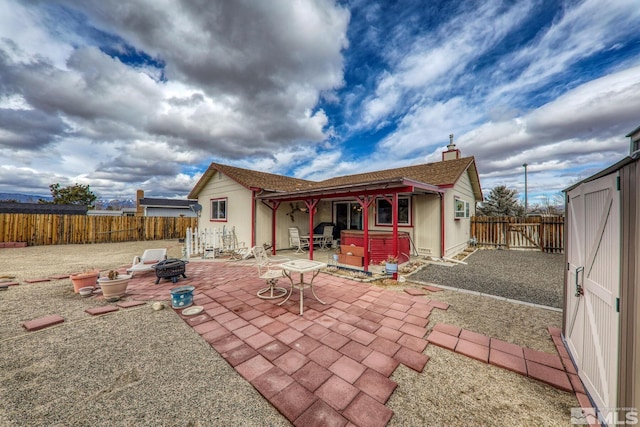 rear view of house with a hot tub, a patio, and a fire pit