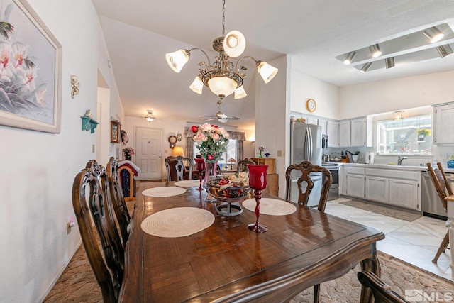 dining area with sink and ceiling fan with notable chandelier