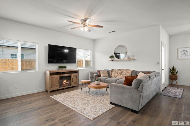 living room featuring ceiling fan and dark hardwood / wood-style flooring