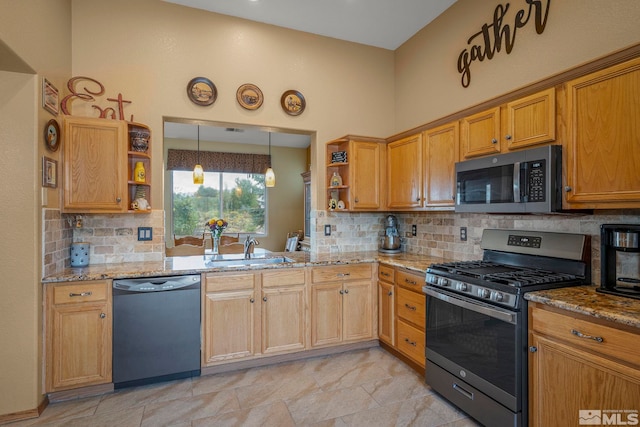 kitchen featuring light stone counters, sink, backsplash, and appliances with stainless steel finishes