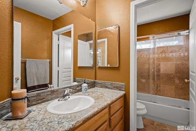 full bathroom with tiled shower / bath combo, vanity, and toilet