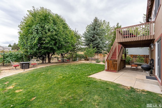 view of yard with a wooden deck and a patio area