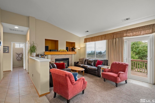 tiled living room with a tiled fireplace and lofted ceiling