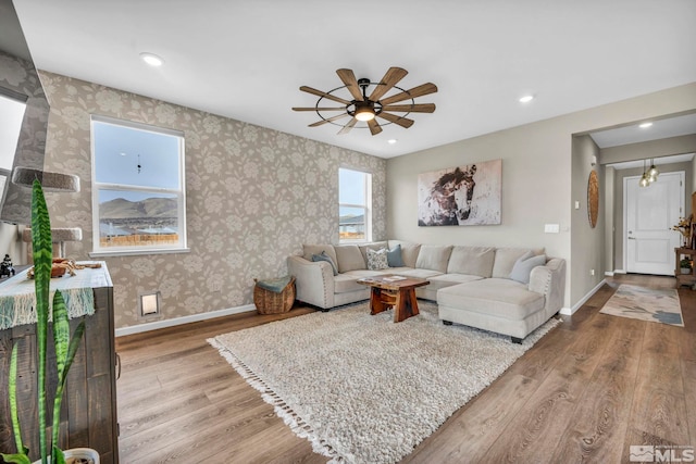 living room featuring ceiling fan and light hardwood / wood-style floors