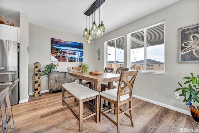 dining area with a chandelier and light wood-type flooring