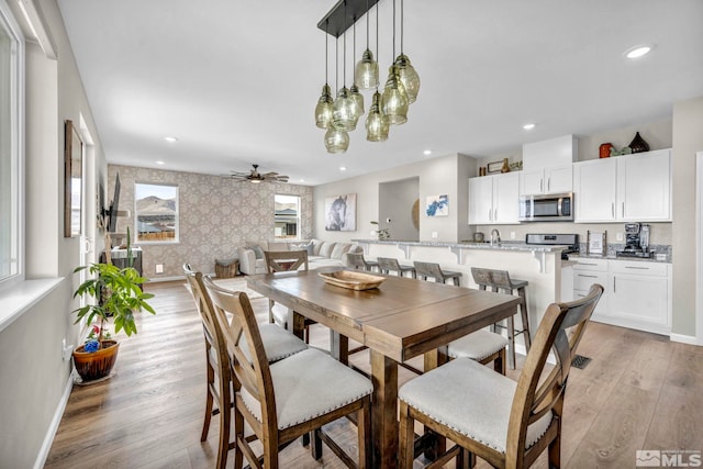 dining area with ceiling fan and light hardwood / wood-style floors